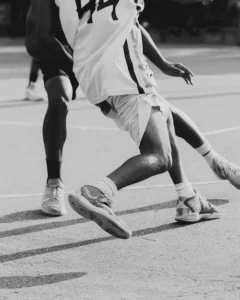 Close-up of basketball players’ legs and feet in motion on the court.