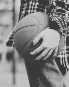 Close-up of hands holding a basketball.