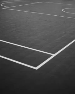 Basketball court lines forming a corner on an outdoor court.
